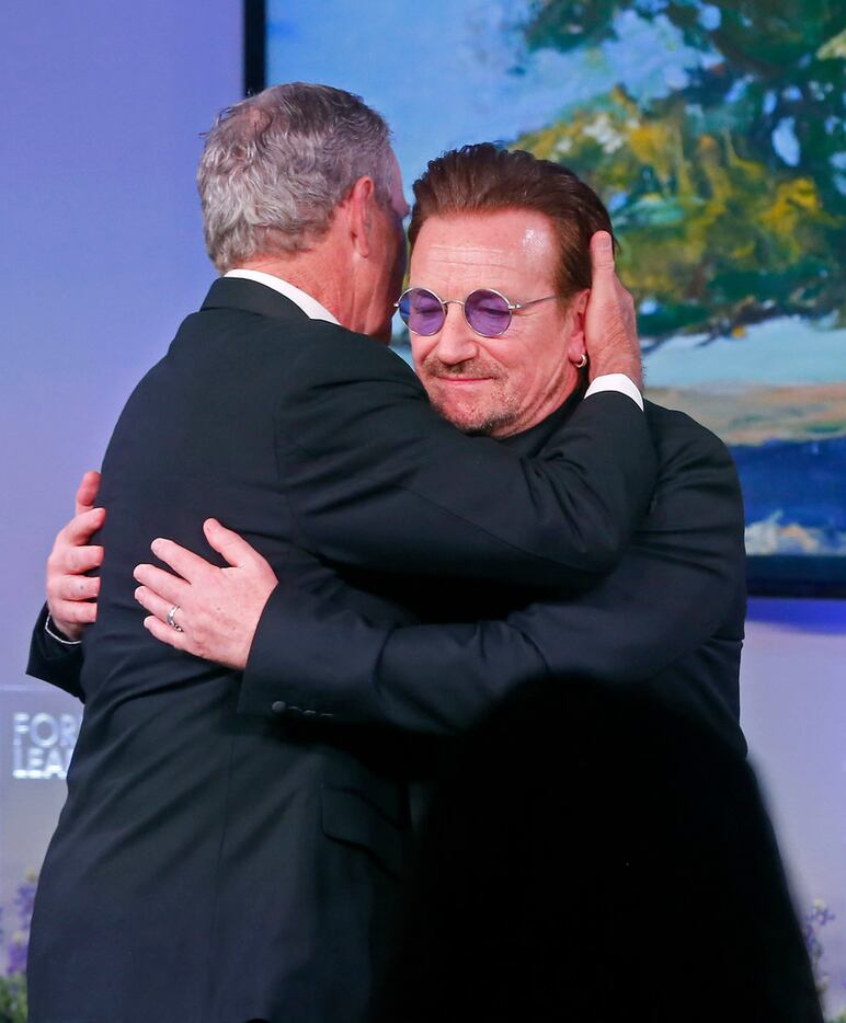 Former President George W. Bush hugs Bono, a recipient of the George W. Bush Medal for...