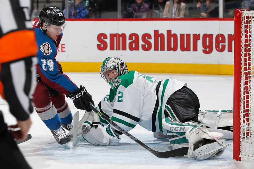 DENVER, CO - JANUARY 10:  Nathan MacKinnon #29 of the Colorado Avalanche gets the puck past...
