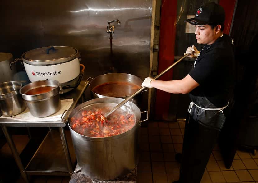 Juan G., a cook, stirs crawfish in the boiler at The Boiling Crab in Dallas on Saturday,...