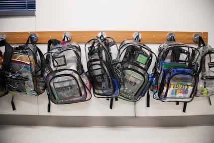 Clear backpacks belonging to students are hung up in a classroom during the first day of...