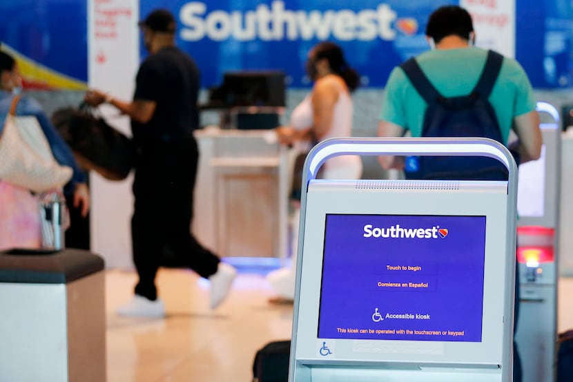 Southwest Airlines passengers prepare to check their baggage at Dallas Love Field Airport in...