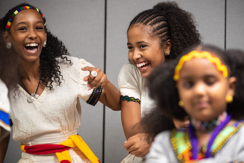 Dania Asefa, left, and Rakeb Mengistu, right, laugh and joke as they wait to dance in this...