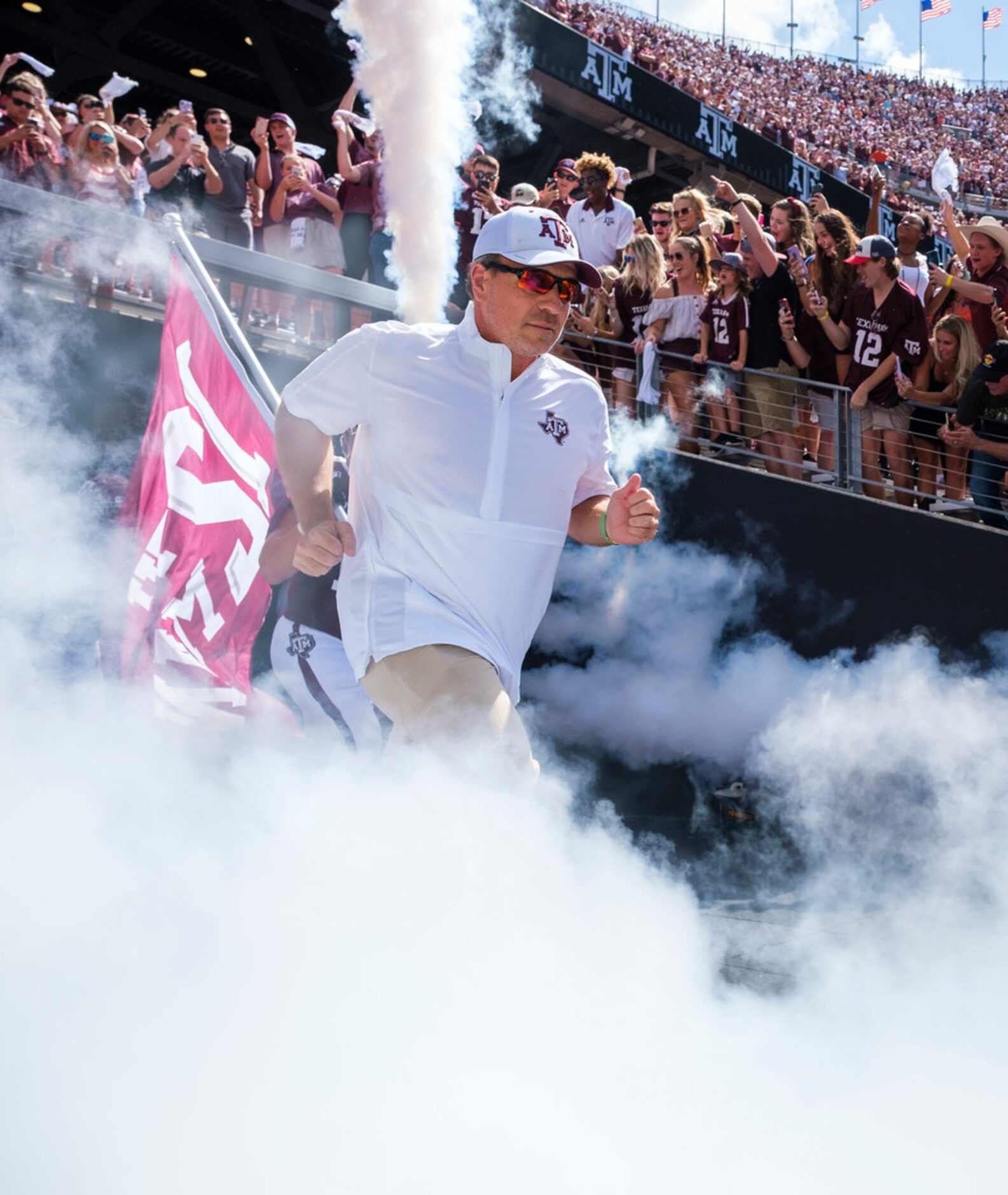 Texas A&M head coach Jimbo Fisher leads his team as they take the field to face Auburn in an...