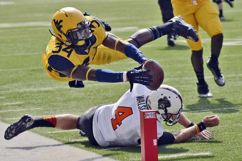 West Virginia' Ishmael Banks (34) reaches over the goal line for a touchdown after returning...