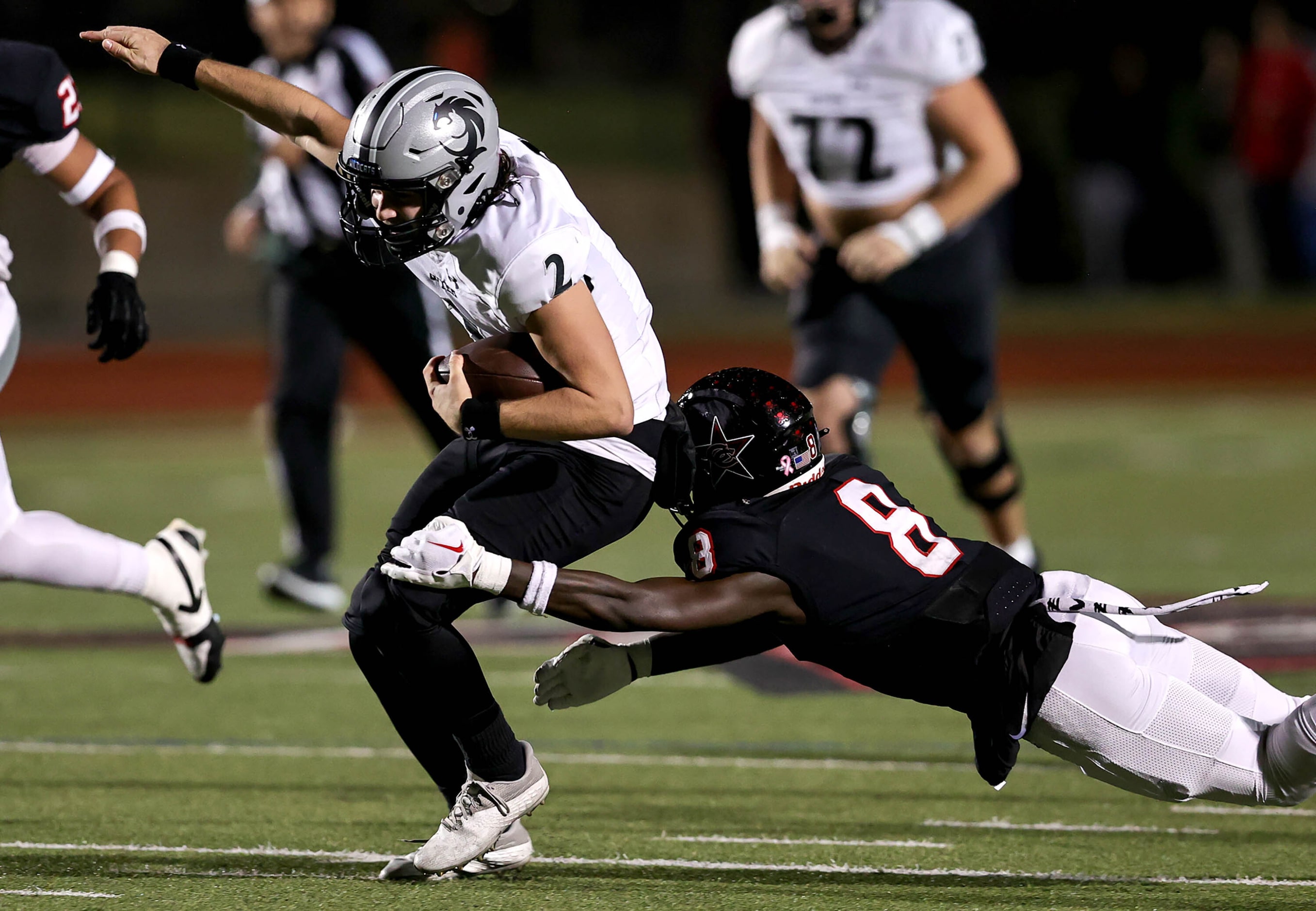 Denton Guyer quarterback Logan McLaughlin (2) scrambles and is finally brought down by...