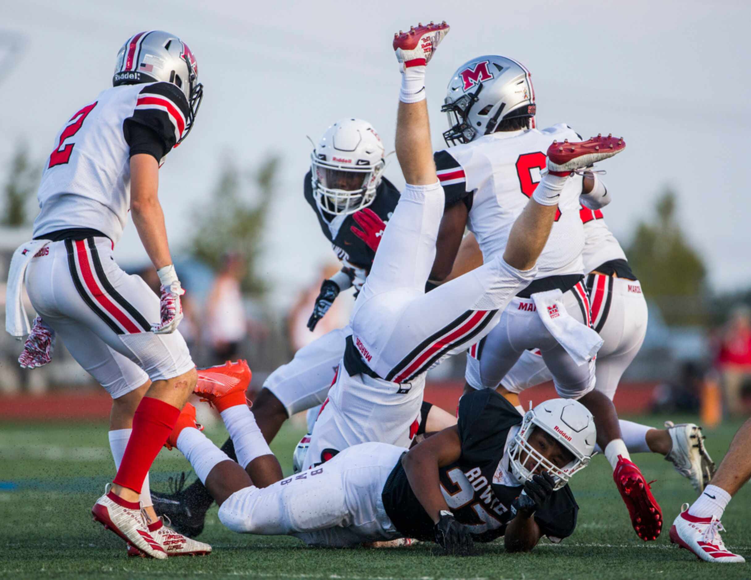 Flower Mound Marcus wide receiver Alex Fontaine (6) is upended by Arlington Bowie defensive...