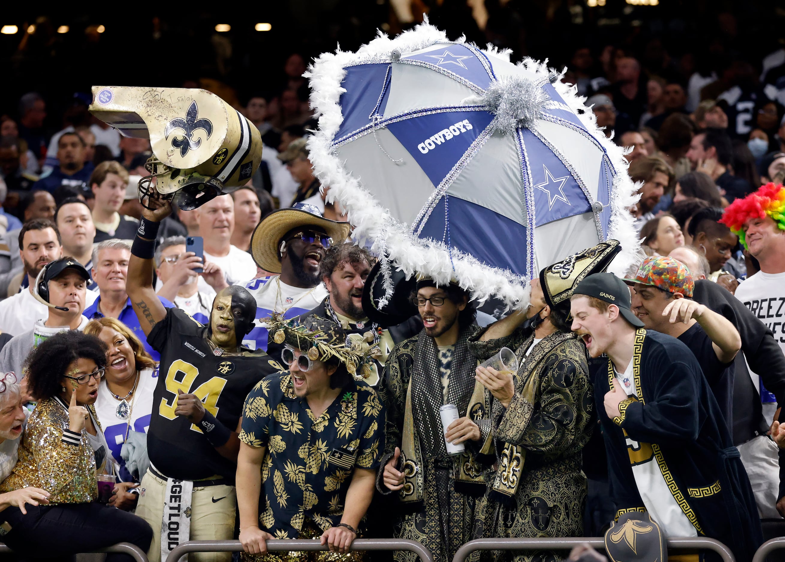 New Orleans Saints fans try and pull an umbrella from a Dallas Cowboys fan in the fourth...
