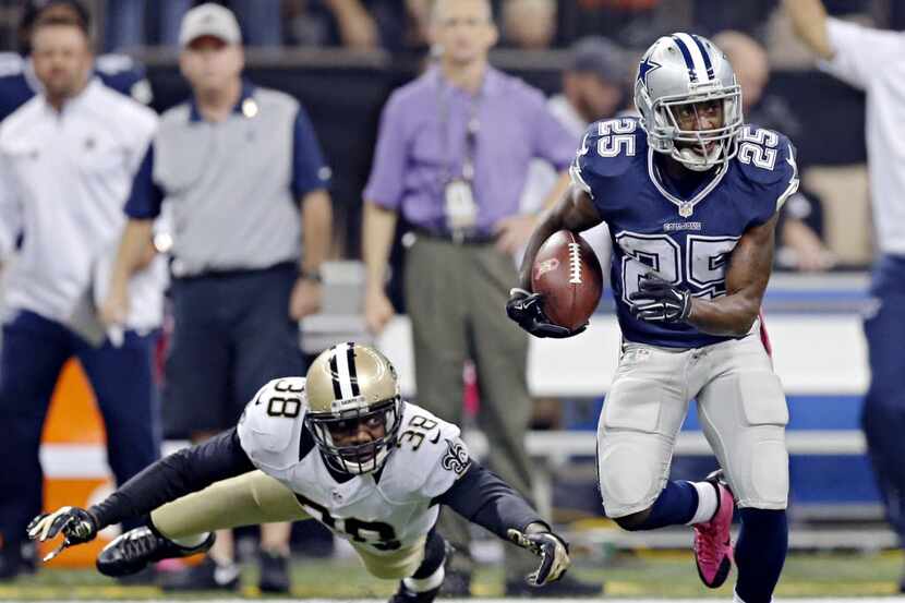 Dallas Cowboys running back Lance Dunbar (25) gets by a tackle attempt by New Orleans Saints...