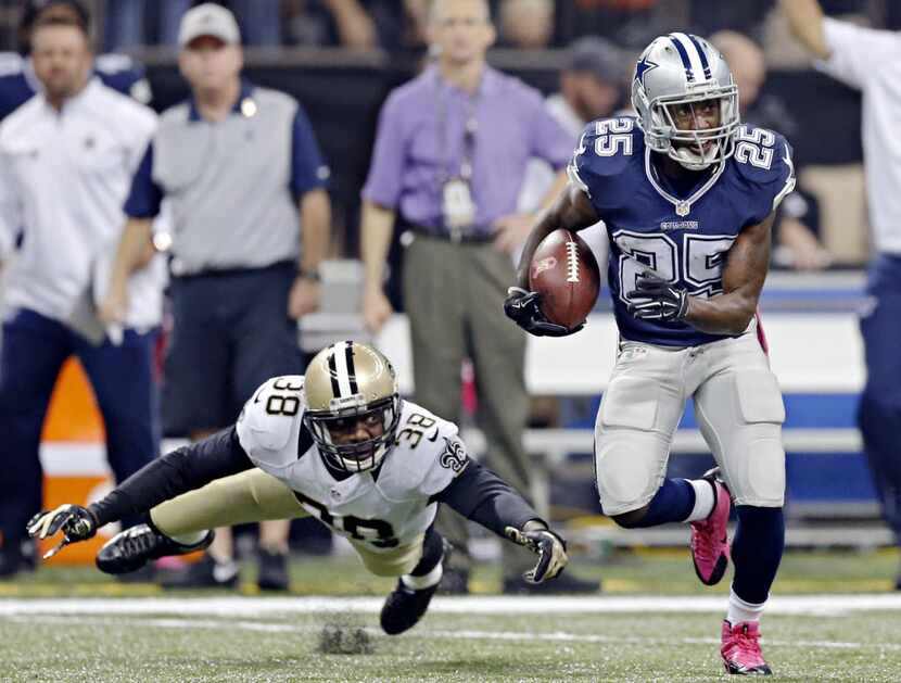 FILE — Dallas Cowboys running back Lance Dunbar (25) gets by a tackle attempt by New Orleans...