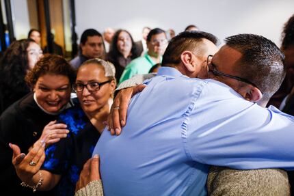 Surrounded by family members, Martin Santillan (right) embraces his brother Pedro Martinez...