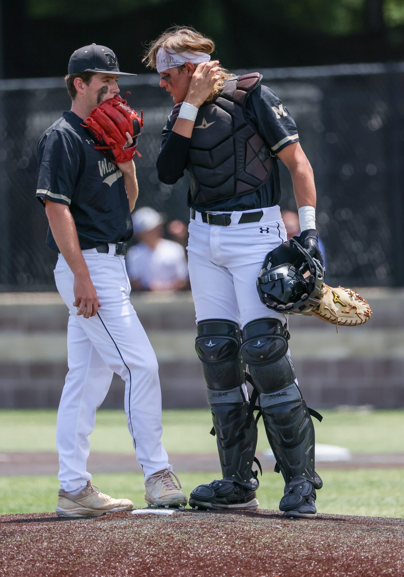 Mansfield pitcher Ben Watson (left) and catcher Parker Burt talk between pitches of an area...