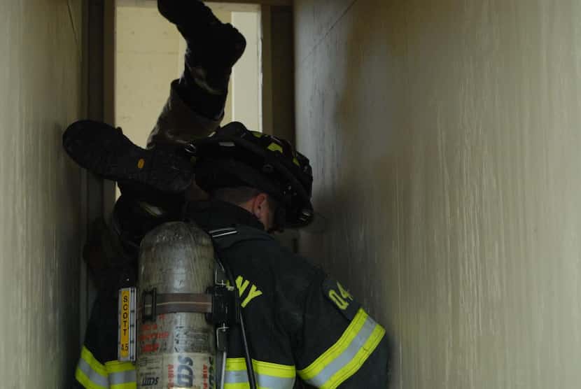 
Firefighters Jeremy McGar, foreground, and Jeff Luse participate in the Denver Drill at The...