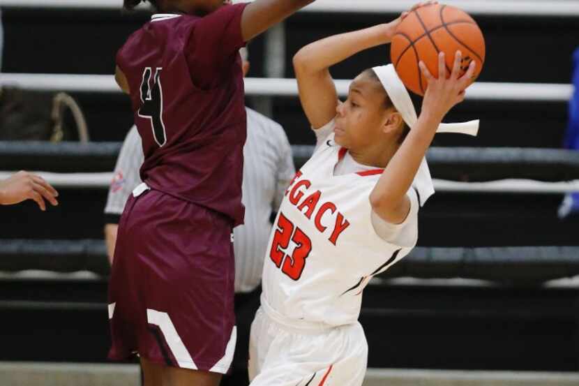 Mansfield Legacy freshman guard Harmoni Turner (right) looks for room against Mansfield...