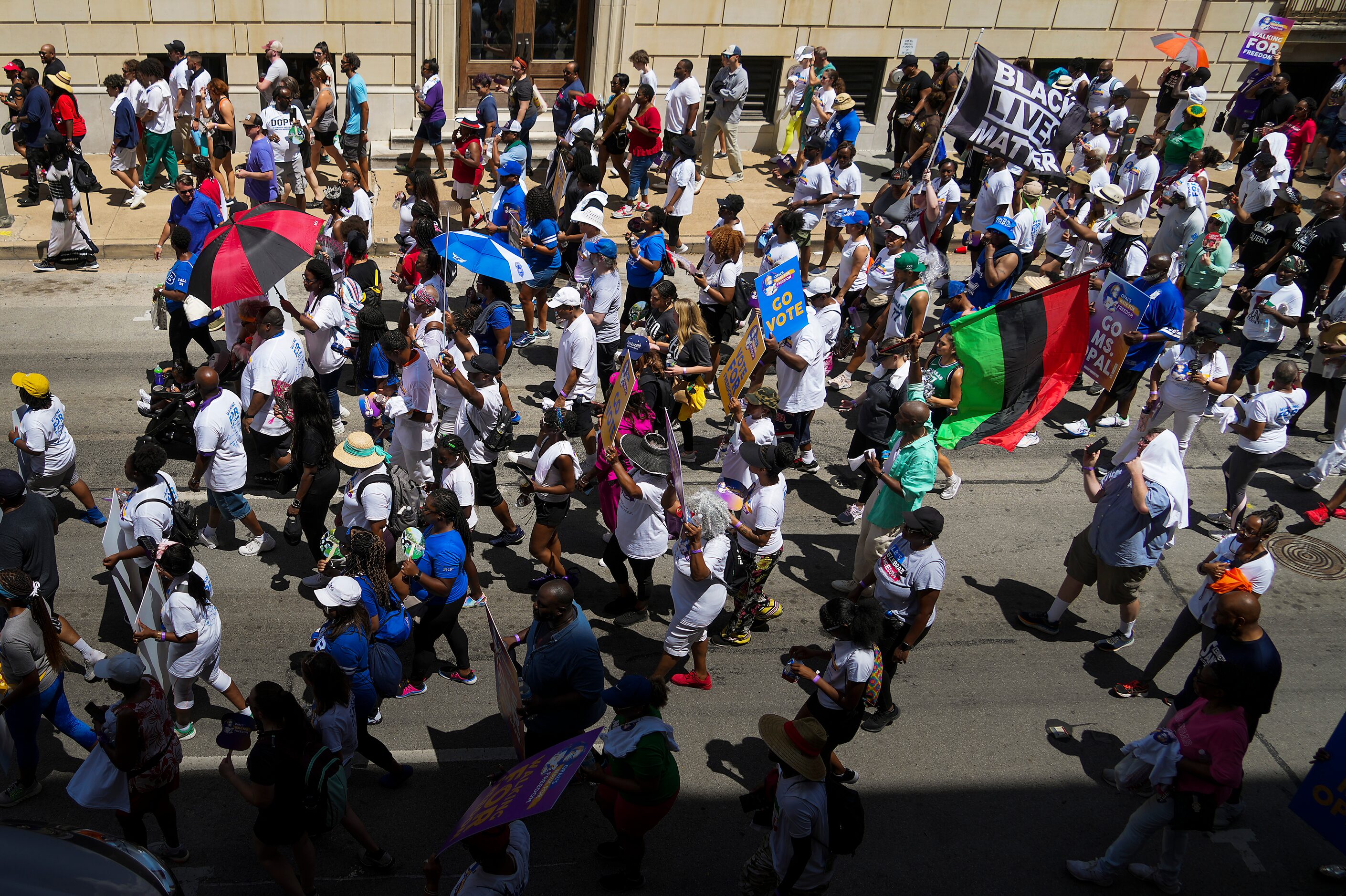 Opal Lee (left, bottom, under red and black umbrella) leads hundreds of walkers downtown...