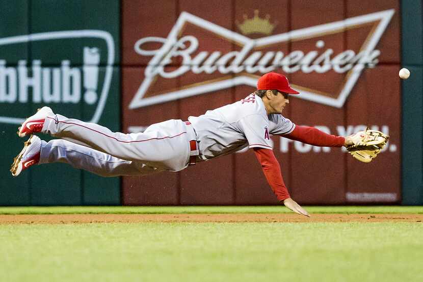 Los Angeles Angels third baseman David Freese can't make a diving play on a single by Texas...