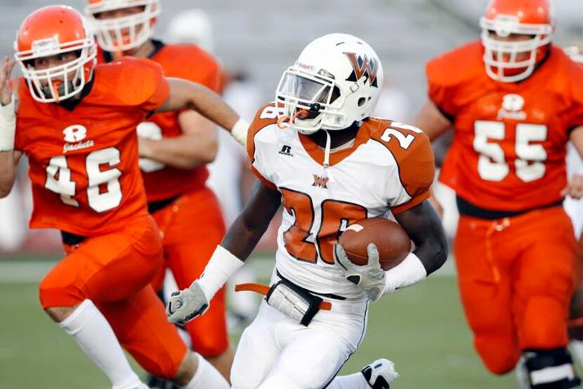 West Mesquite's Courtland Smith (26) runs for a first down as Rockwall defenders Andrew...