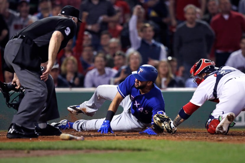 Boston Red Sox catcher Sandy Leon, right, makes the tag, catching Texas Rangers' Nomar...