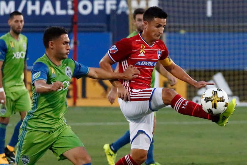 FC Dallas midfielder Mauro Diaz (10) controls the soccer ball next to Seattle Sounders...