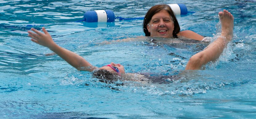 Beckie Koelpin looks on as her daughter Ellie practices her backstroke form at the Lake...