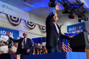 President Joe Biden waves to the crowd as Wisconsin Gov. Tony Evers, left, looks on at a...