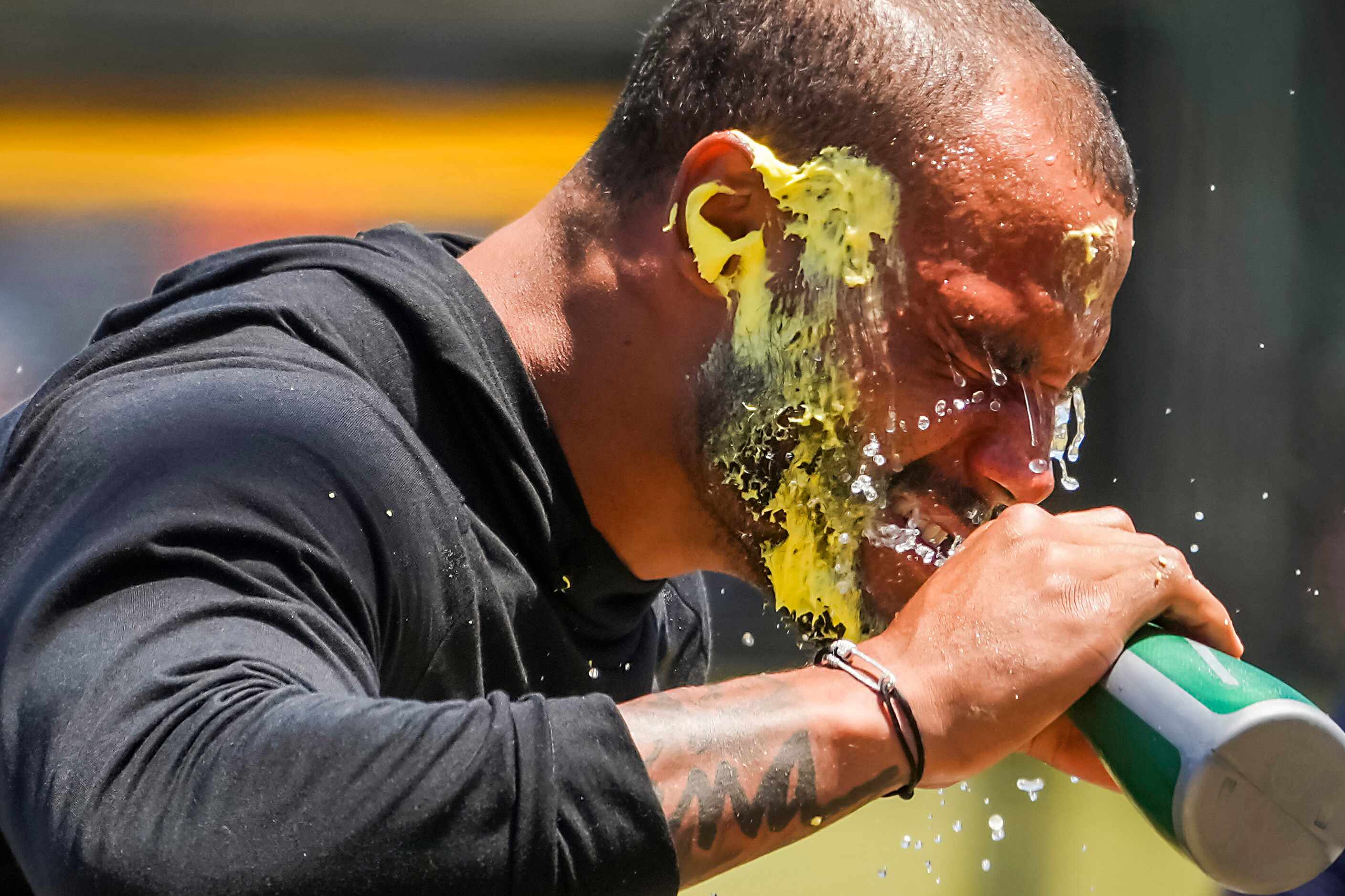 Dallas Cowboys quarterback Dak Prescott cleans icing off his face after getting a cake to...