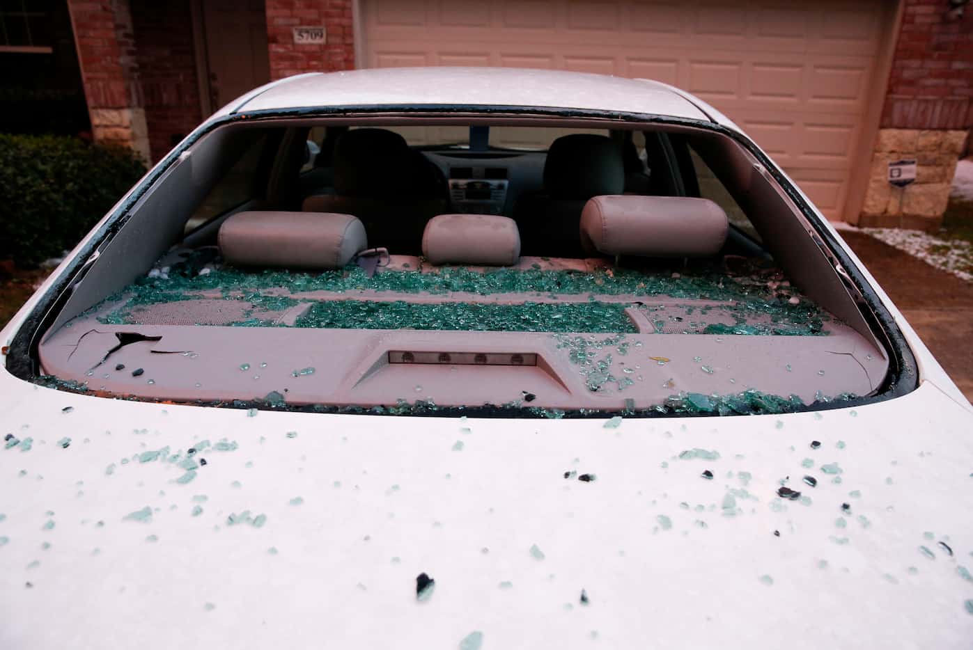 A car with a broken windshield after hail pounded houses and cars in McKinney on Sunday