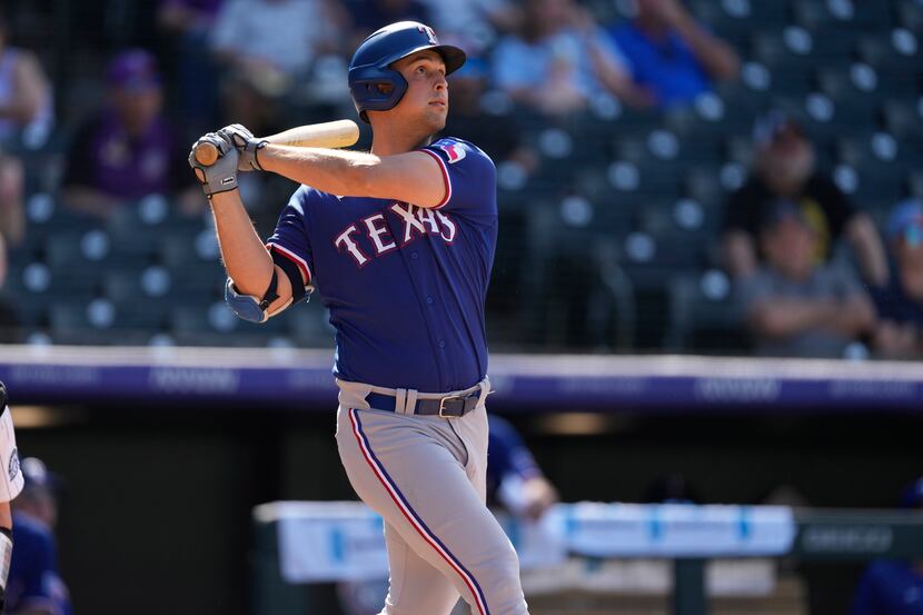 Texas Rangers' Nathaniel Lowe follows the flight of his three-run home run off Colorado...