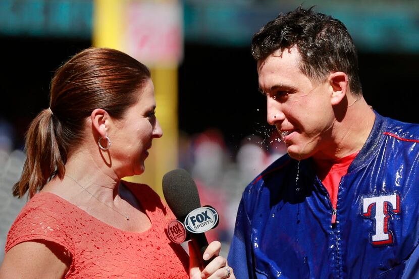 For Sports broadcaster Emily Jones (left) leans away from wet Texas Rangers starting pitcher...