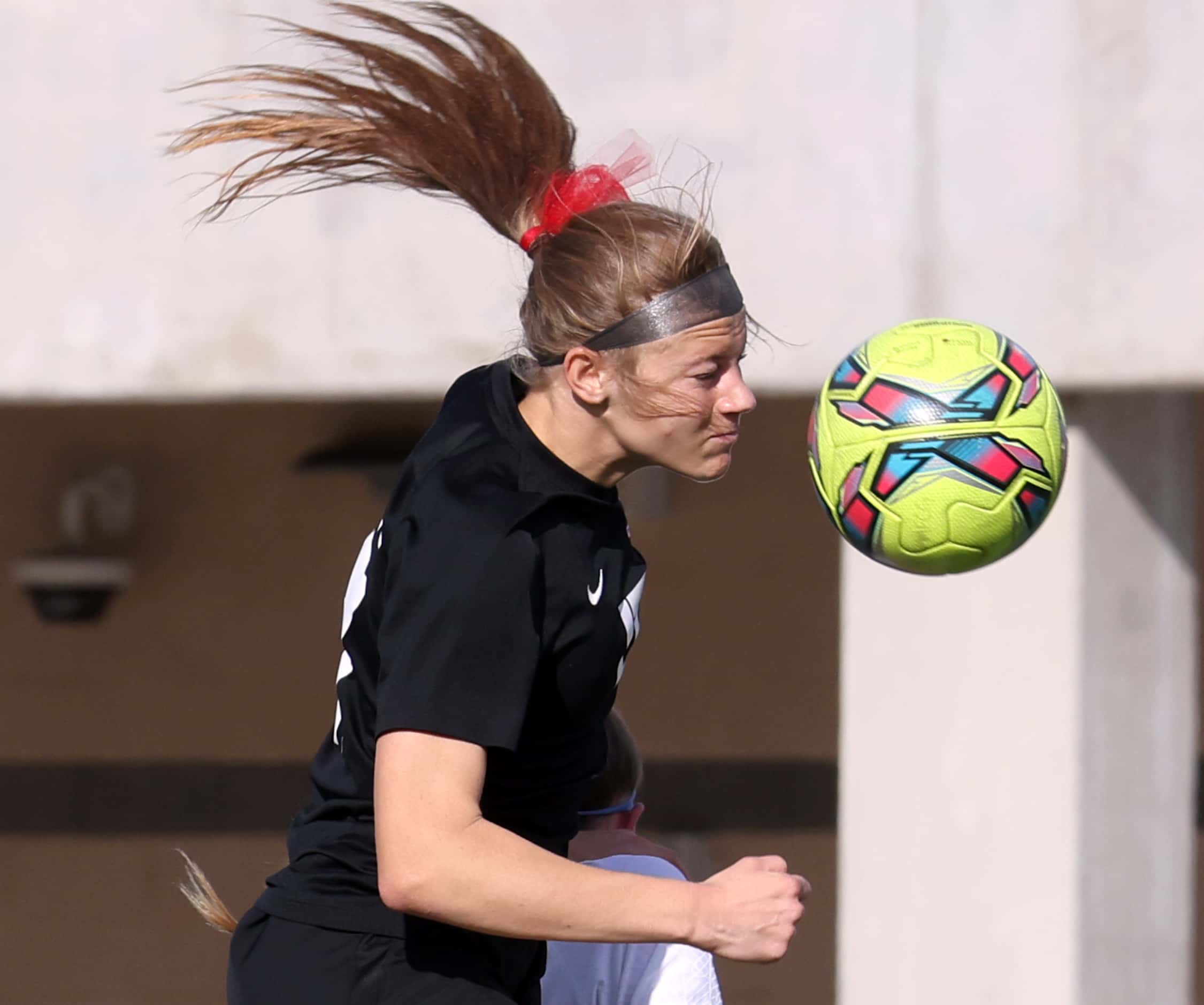 Flower Mound Marcus forward Madi Patterson (17) heads the ball to a teammate during first...