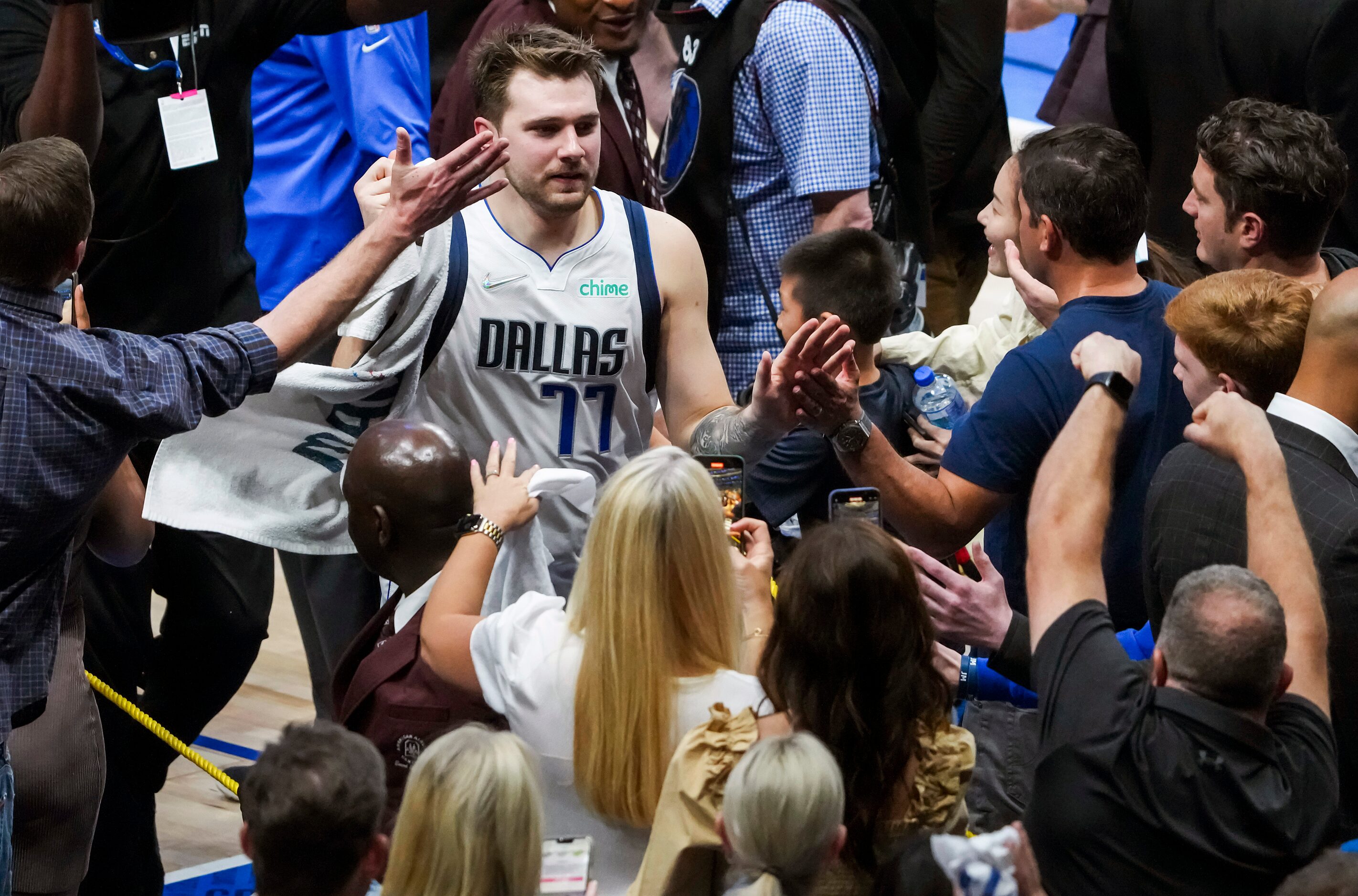 Dallas Mavericks guard Luka Doncic high fives fans as he leaves the court  after a 103-94...