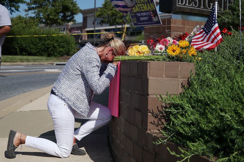 Lynne Griffin pays her respects at a makeshift memorial near the Capital Gazette...