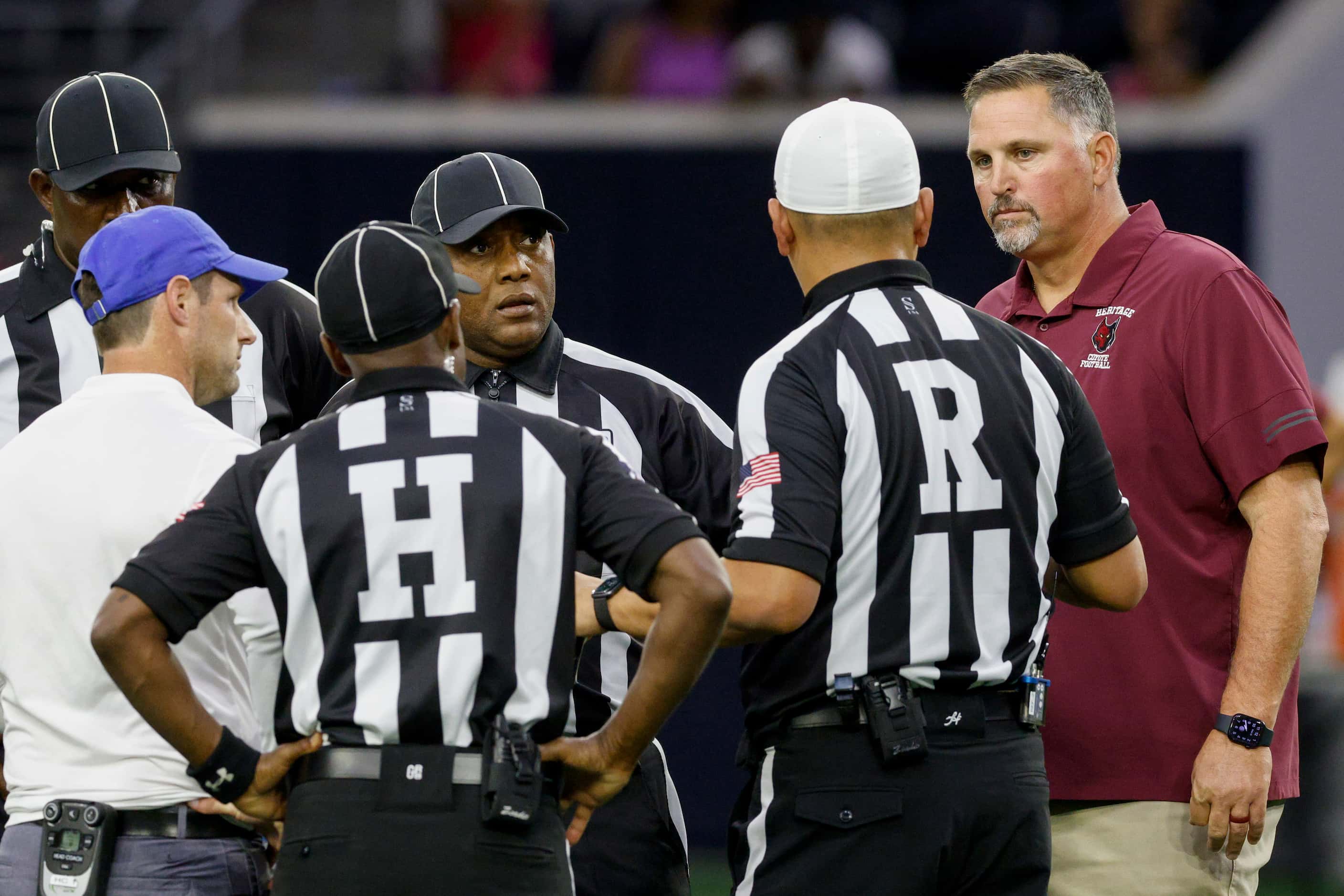 Frisco Heritage head coach Kenneth Gilchrist (right) talks with the referees and Frisco head...