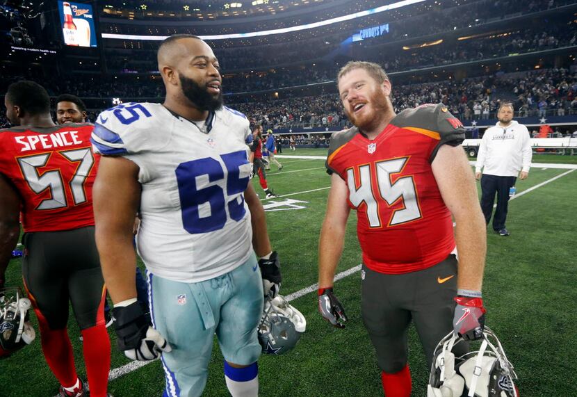 Dallas Cowboys' Ronald Leary (65) and Tampa Bay Buccaneers' Alan Cross (45) talk after their...