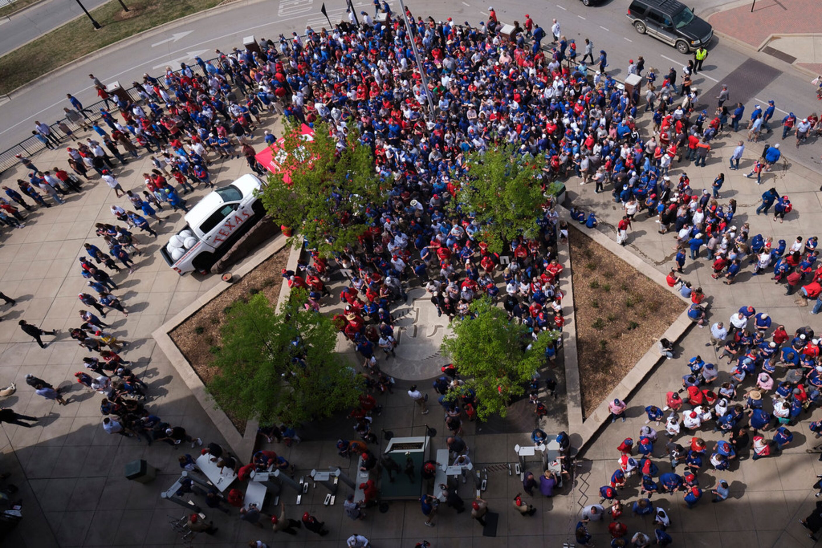 About one half hour before first pitch, fans wait in long lines to go through security and...