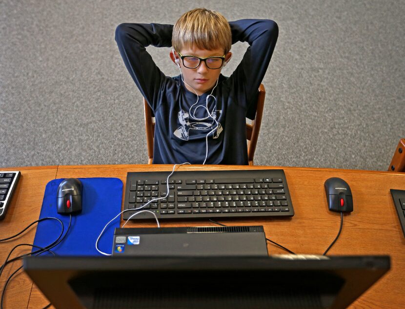 Fourth-grader Landon Wood, 9, uses the Voice Dream Reader app on a desktop computer in the...