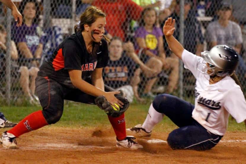 Flower Mound Marcus third baseman Bonna Molina (4) is late with the tag, as Flower Mound's...