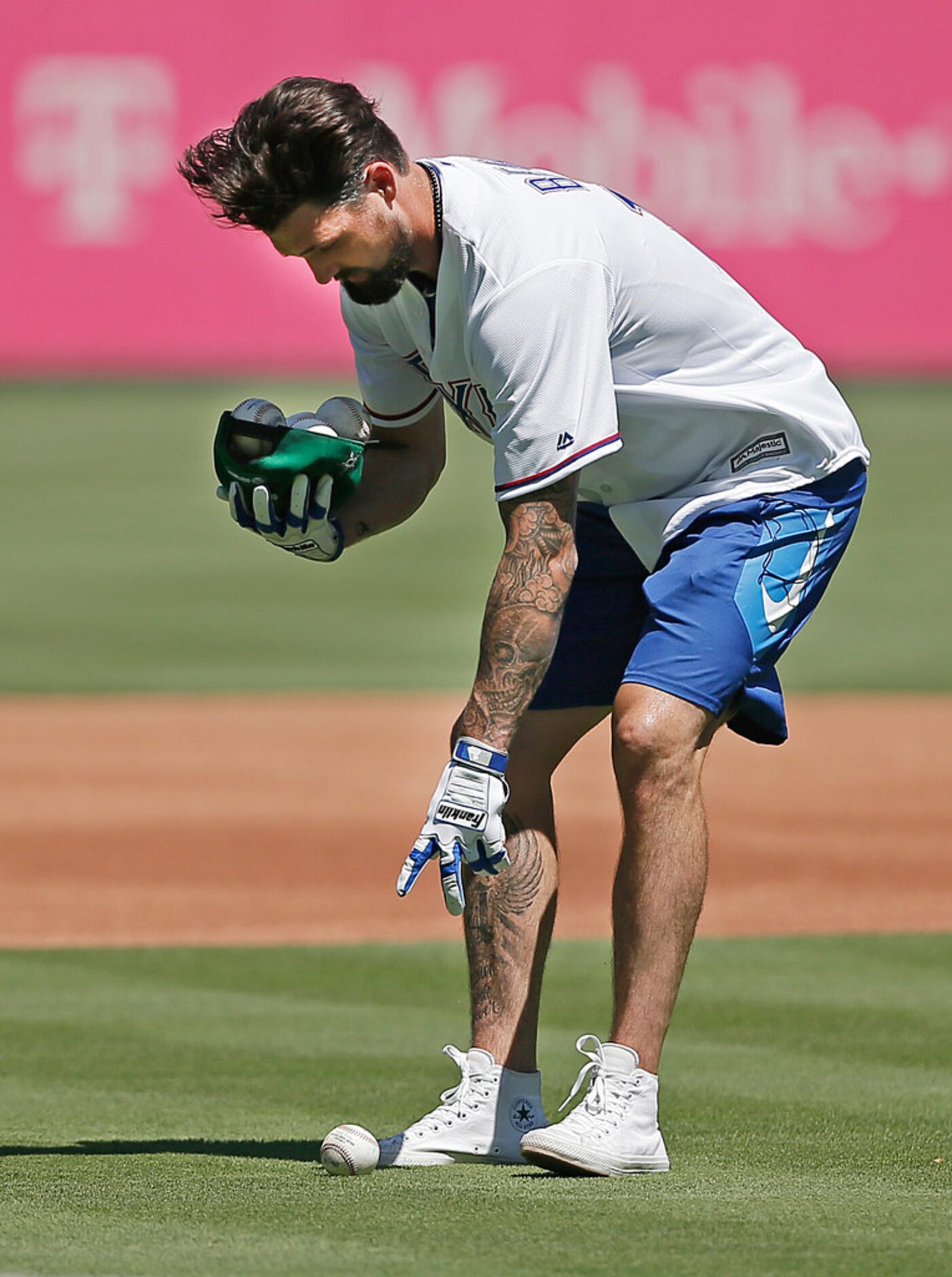 Dallas Stars captain Jamie Benn uses his ball cap to collect baseballs from the infield...