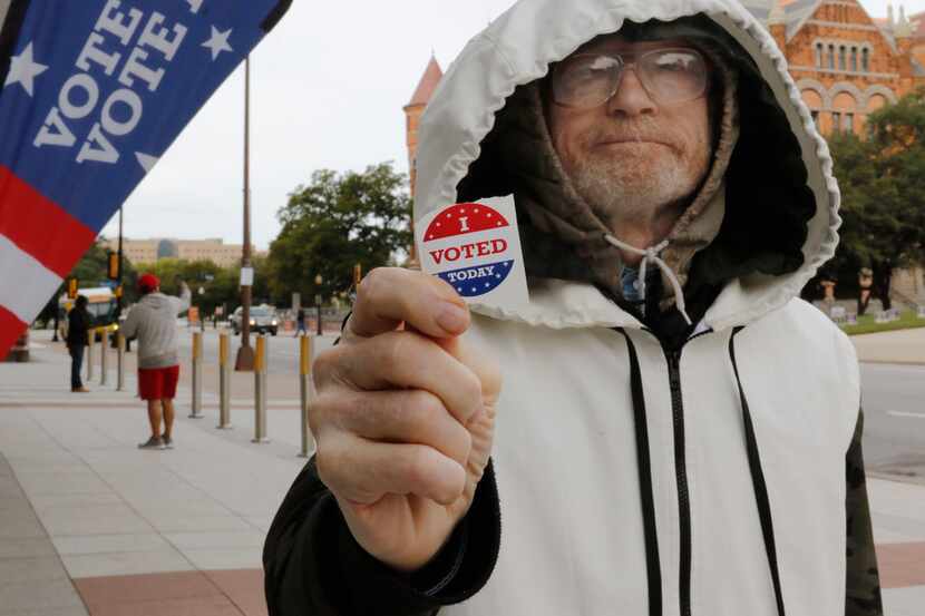 Hollis Gerald Bintliff show his "I VOTED Today" sticker after voting early at the George L....