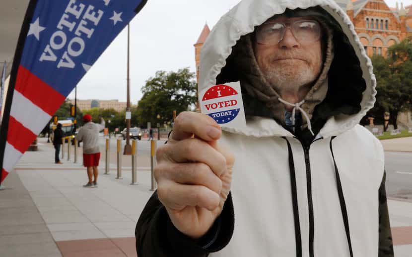 Hollis Gerald Bintliff show his "I VOTED Today" sticker after voting early at the George L....