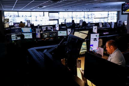 Employees work at American Airlines command center, where the airline directs its ground...