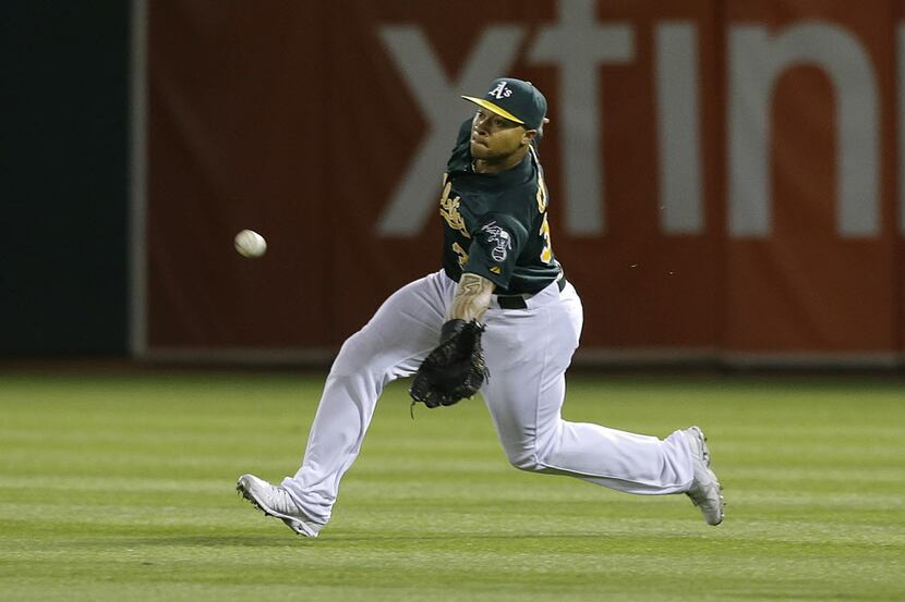 Oakland Athletics right fielder Michael Choice catches a fly ball hit by Texas Rangers' Alex...