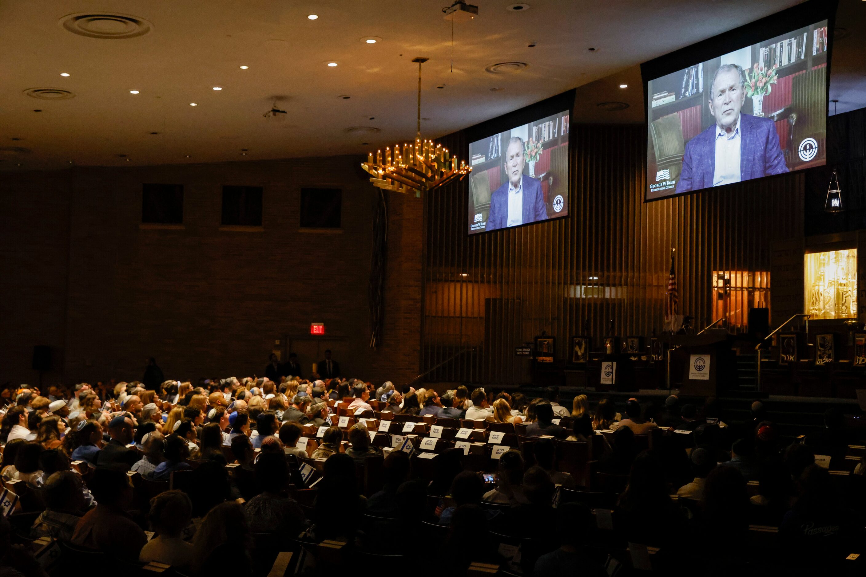 A video message from former President George W. Bush plays during a community event...