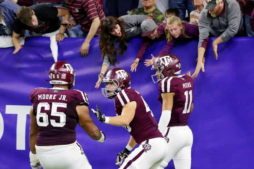 Texas A&M offensive lineman Dan Moore Jr. (65) and tight end Ryan Renick, middle, celebrate...