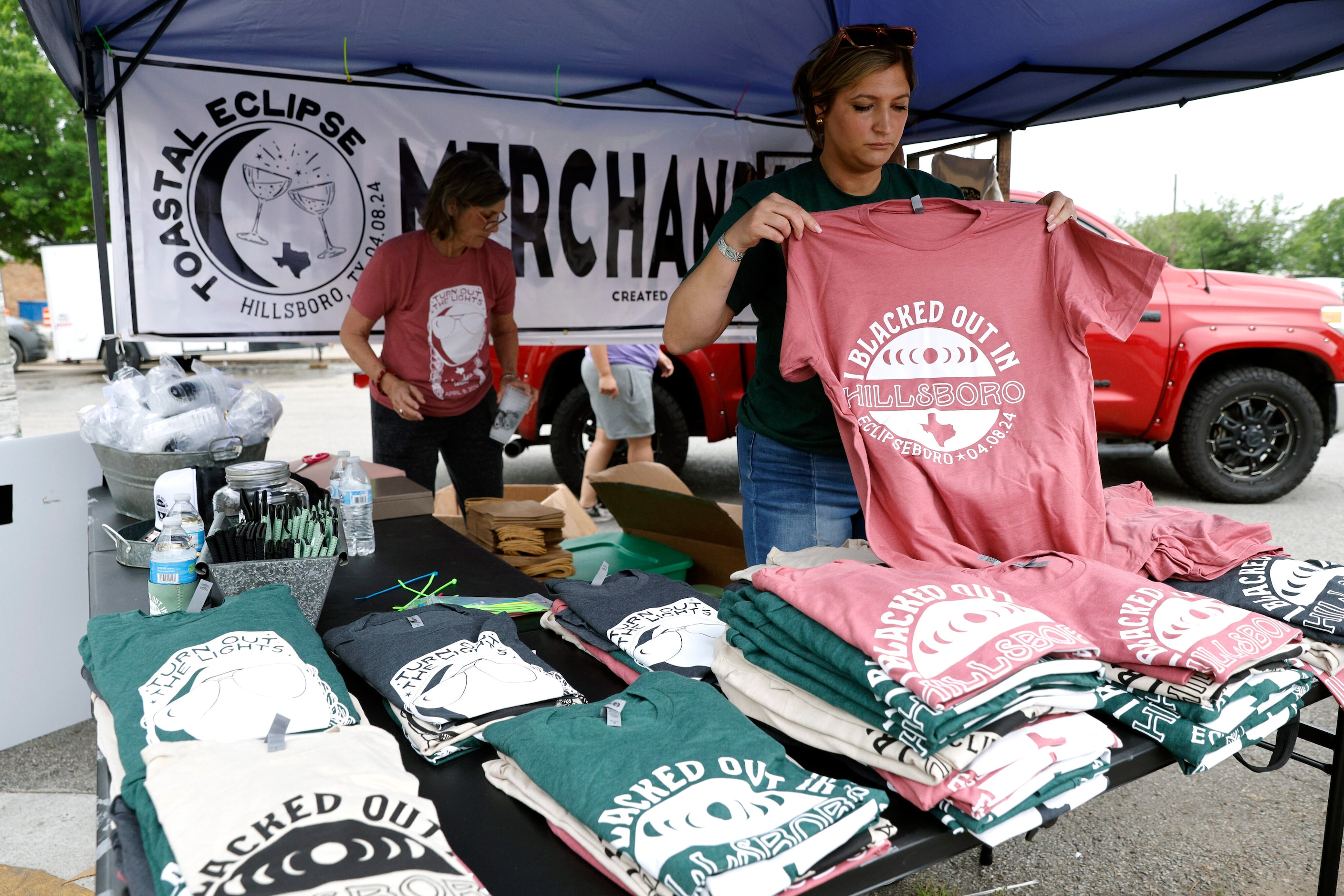 Emily Craig of Hillsboro folds t-shirts to sale outside of the Hill County Courthouse before...