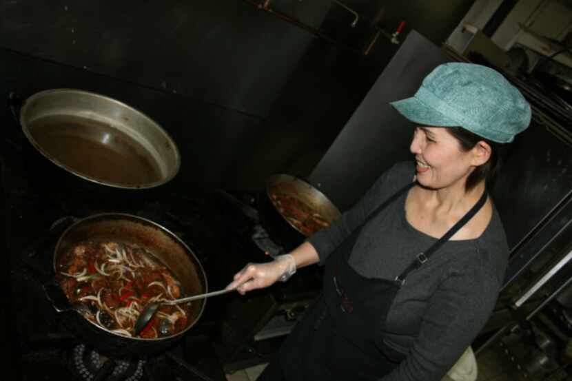 Nam Hua stirs at a pot of spicy catfish at her restaurant, Nam Hua Vietnamese Cuisine in...