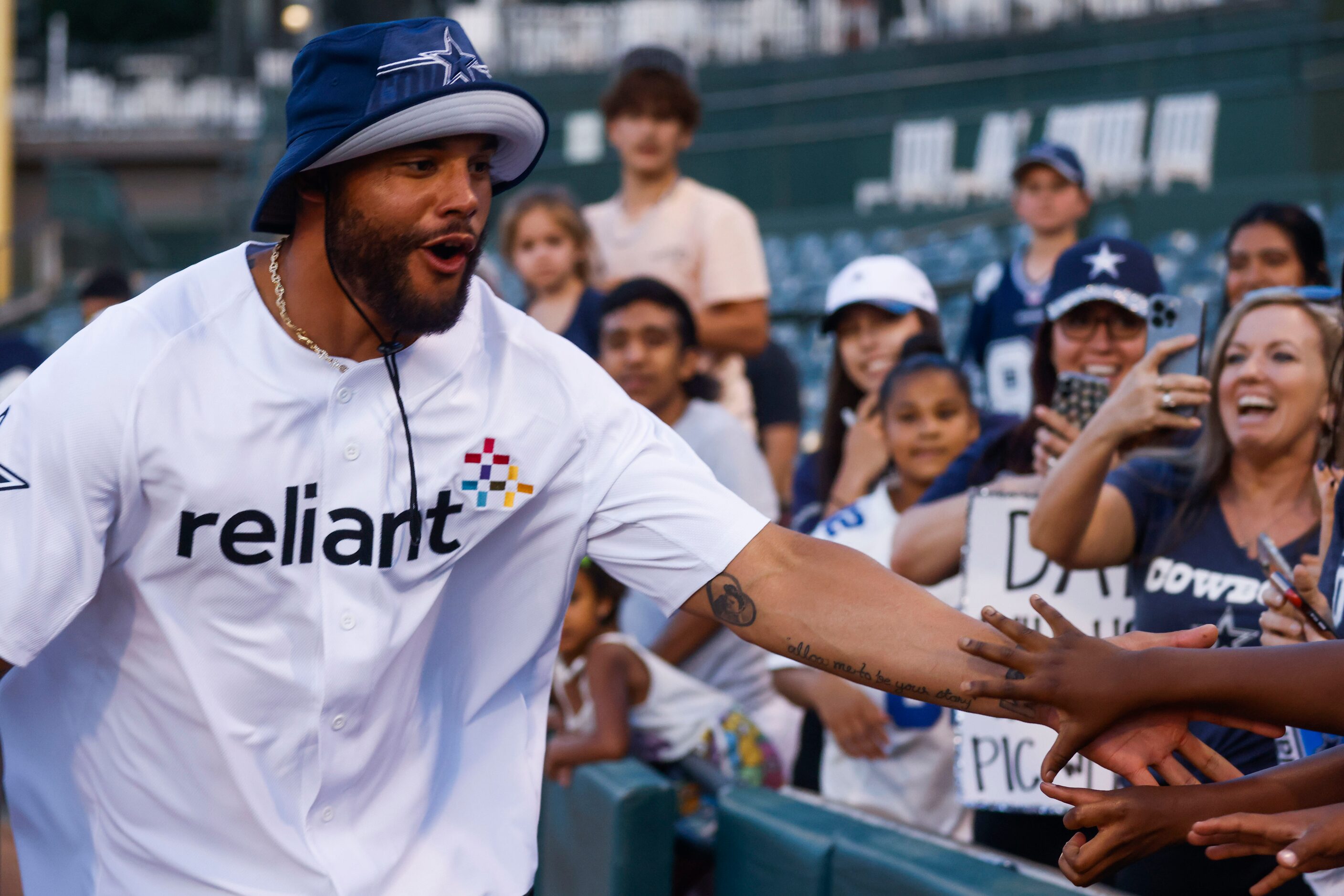 Dallas Cowboys QB Dak Prescott cheers with fans during annual home run derby on Wednesday,...