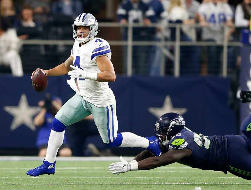 Dallas Cowboys quarterback Dak Prescott (4) scrambles away from Seattle Seahawks defensive...