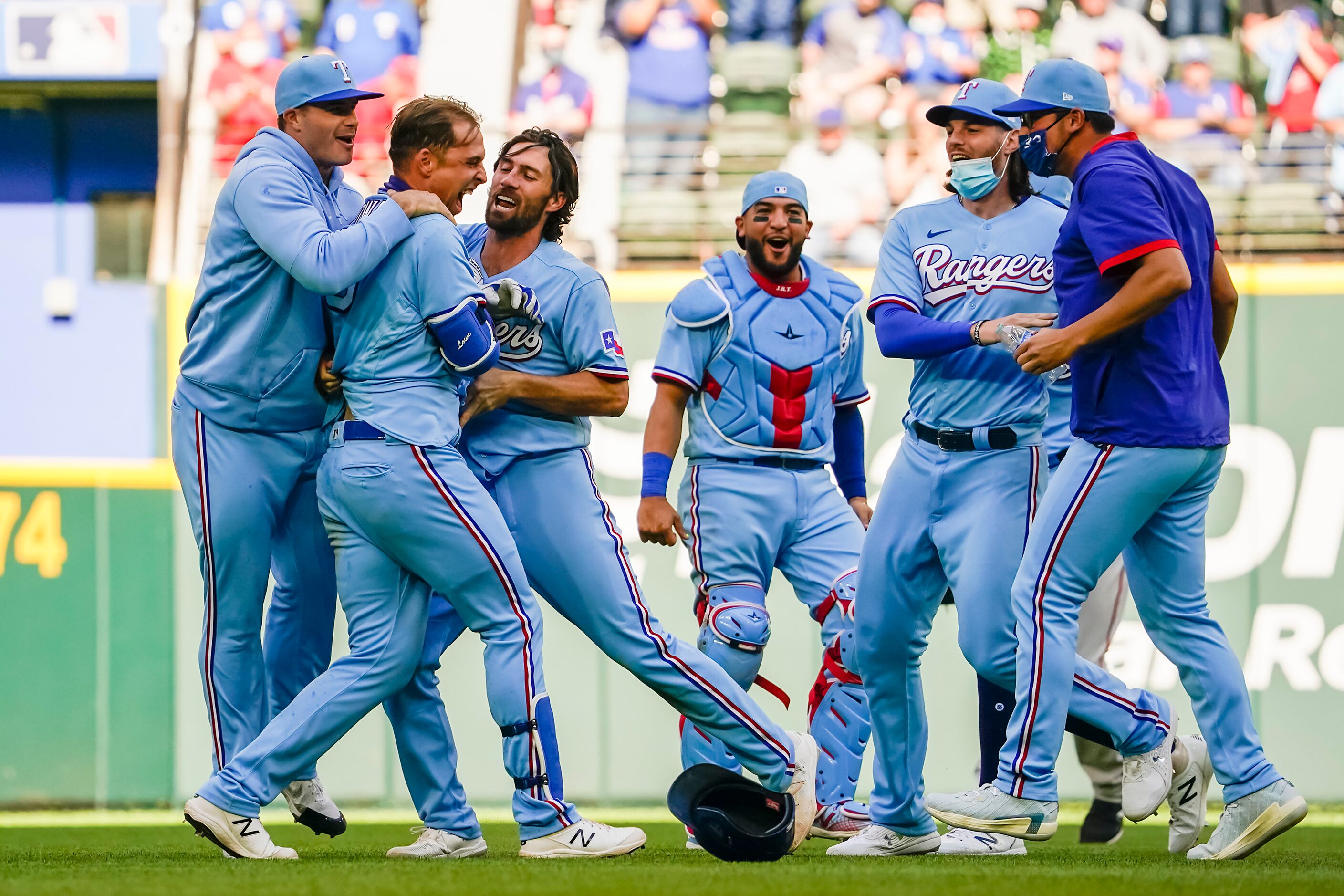 Texas Rangers first baseman Nate Lowe is mobbed by teammates after hitting a walk-off single...