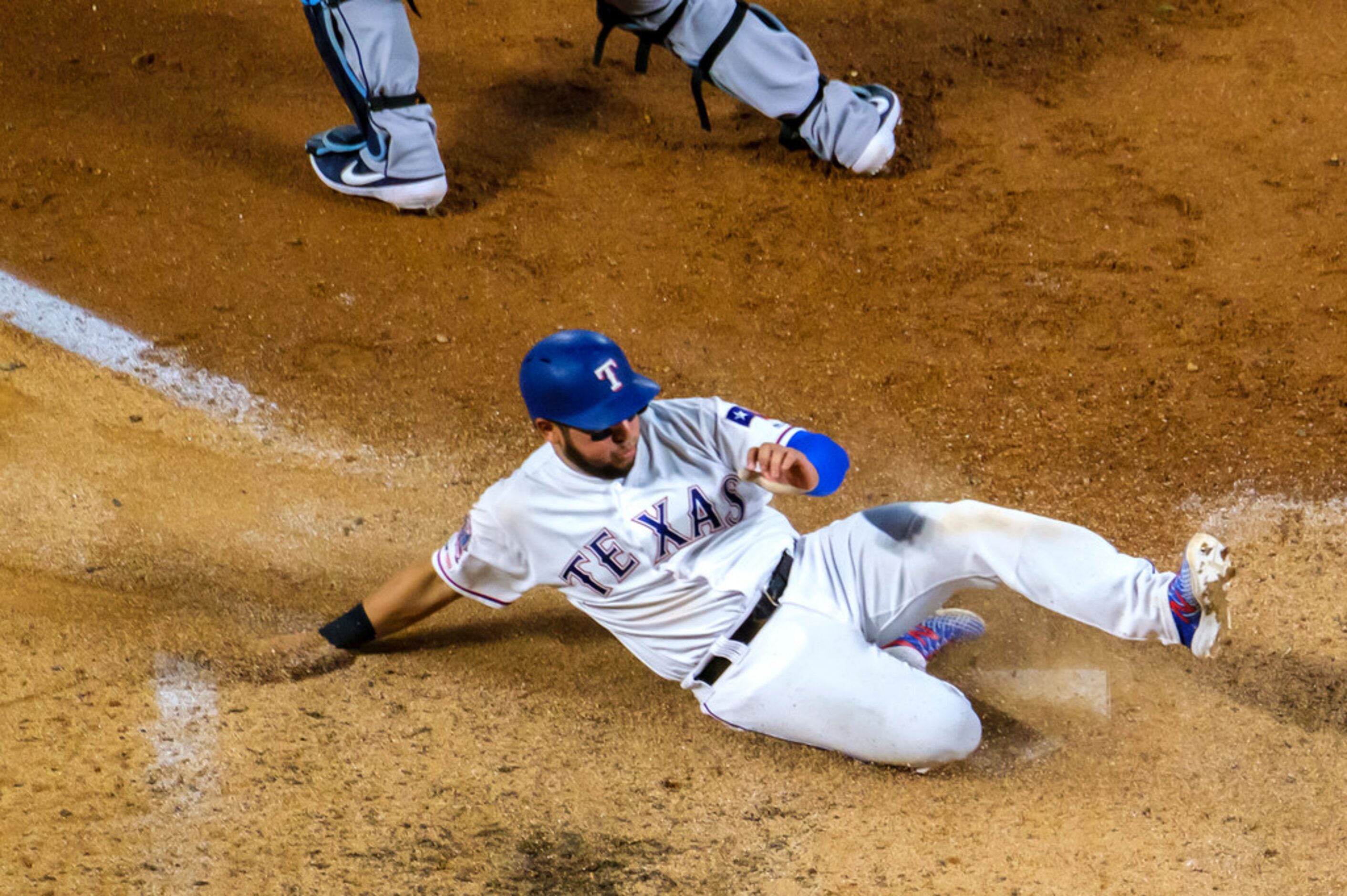 Texas Rangers catcher Jose Trevino slides home to score on a single by Texas Rangers...