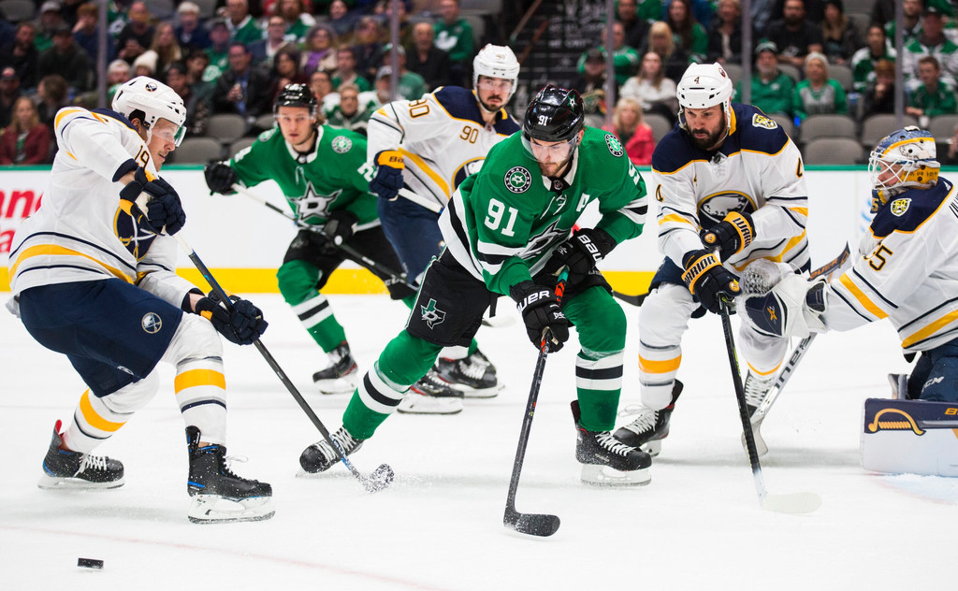 The Dallas Stars' Tyler Seguin (91) makes a pass past the Buffalo Sabres' Jake McCabe, left,...